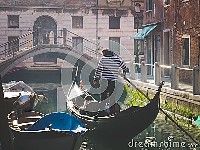 Couple of tourists enjoying gondola tour in the water channel of Editorial Stock Photo