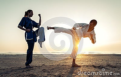 Couple training in martial arts on the beach Stock Photo