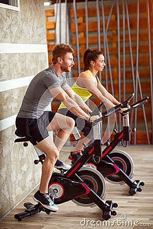 Couple trains on bike in gym Stock Photo