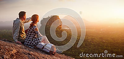 Couple travelers watch beautiful sunset near famous rocky plateau Lion peak, Sigiriya. Sri Lanka Stock Photo