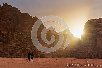 Couple travelling in Wadi Rum desert in Jordan, enjoying beautiful sunrise in the morning Stock Photo