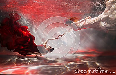 couple two women swim underwater, girl fantasy mermaid river nymph long dress tail silk fabric fluttering. Woman fairy Stock Photo