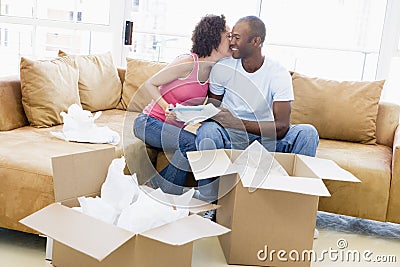 Couple unpacking boxes in new home kissing Stock Photo