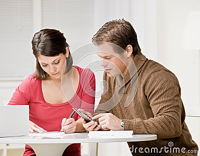 Couple using calculator to pay monthly bills Stock Photo