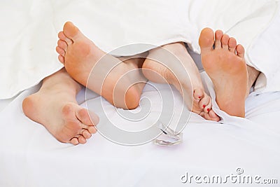 Couple using contraception in bed Stock Photo