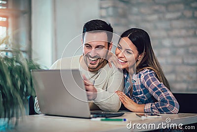 Couple Using Laptop On Desk At Home Stock Photo