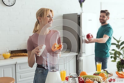 couple of vegans smiling while cooking Stock Photo