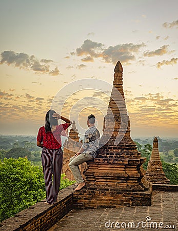 Couple visit Bagan Myanmar, hot air balloon during Sunrise above temples and pagodas of Bagan Stock Photo