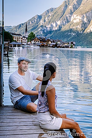 Couple visit Hallstatt village on Hallstatter lake in Austrian Alps Austria Stock Photo