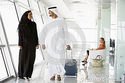 Couple walking through airport departure lounge Stock Photo