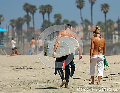 Couple Walking Along Beach Editorial Stock Photo