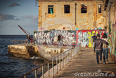 A couple walking in the `Cais do Ginjal` Editorial Stock Photo