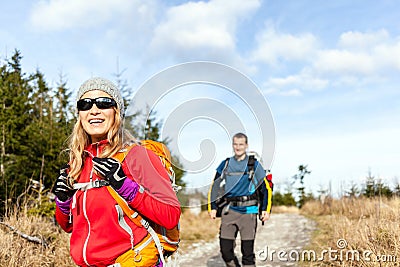 Couple walking and hiking on mountain trail Stock Photo