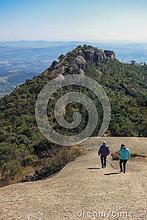 Couple walking over a huge stone of natural monument on the highs, with mountainscape on background Editorial Stock Photo
