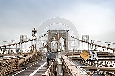 Couple Walking in the Rain on Brooklyn Bridge on a Cold Day of Winter, Manhattan. New York City, USA Editorial Stock Photo