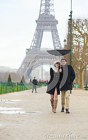 Couple walking under the rain with broken umbrella Stock Photo