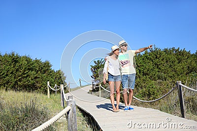 Couple walking on a wooden pontoon admiring nature Stock Photo