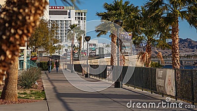 A couple walks at sunrise along Laughlin's Casino Riverwalk outdoor paved fitness walking path. Editorial Stock Photo