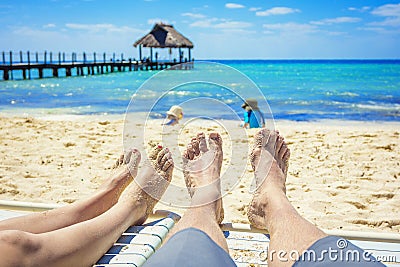 Couple watching their kids playing on the beach on vacation Stock Photo