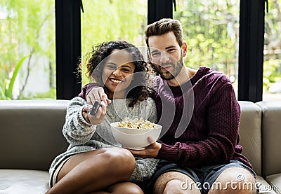 Couple watching TV having popcorn Stock Photo