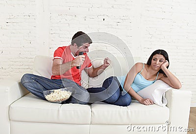 Couple watching tv sport football with man excited celebrating Stock Photo