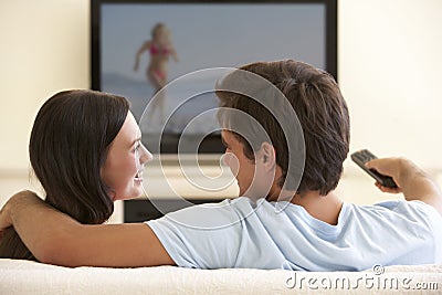 Couple Watching Widescreen TV At Home Stock Photo