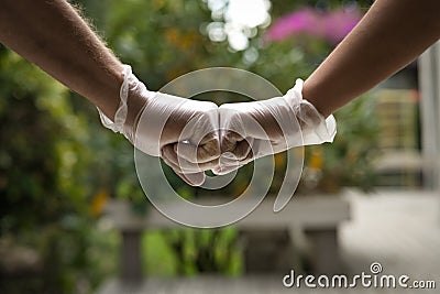 Couple wearing face masks and sanitary gloves that says Â¨Stay home, stay safe Stock Photo