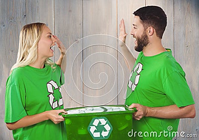 Couple wearing green recycling tshirts giving high five and holding box of recyclables Stock Photo