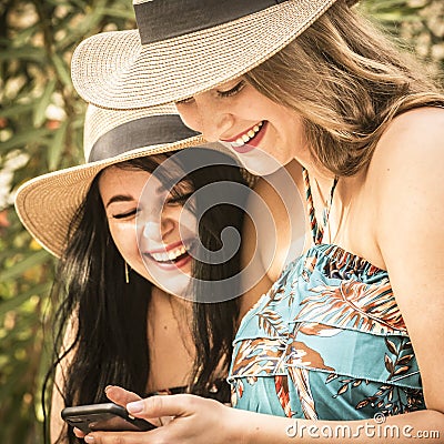 Couple of women young friends have fun together using cellular phone connection in outdoor - concept of girlfriend and lesbian Stock Photo