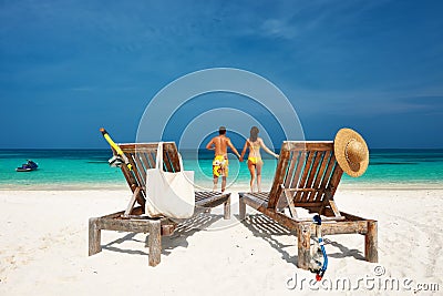 Couple in yellow running on a beach at Maldives Stock Photo