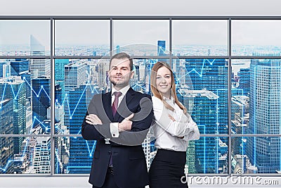 Couple of young managers are standing in the modern panoramic office. New York view. Financial charts are drawn over the panoramic Stock Photo