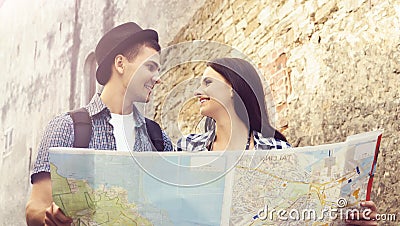 Couple of young travelers with map: walking around town. Stock Photo