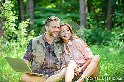 Couple youth spend leisure outdoors with laptop. Man and girl working with laptop at green meadow. Modern technologies Stock Photo