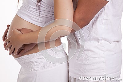 Couples hands around pregnant belly Stock Photo