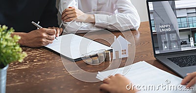 Couples signed a contract to buy a house from the broker. Coin to stack money and model house placed on the table. Stock Photo