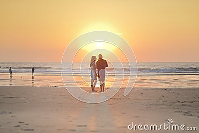 Couples walking on beach at sunset. Editorial Stock Photo