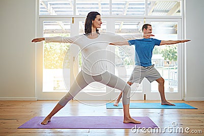 Couples yoga. Full length shot of a mature couple practicing yoga in their home. Stock Photo