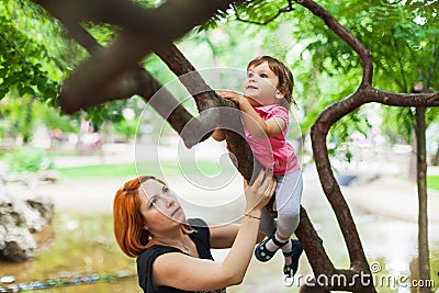 Courageous girl climbing on tree Stock Photo