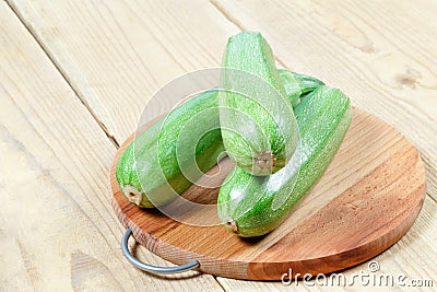 Courgettes zucchini on cutting Board on wooden table Stock Photo