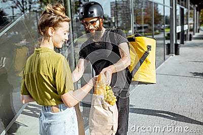 Courier delivering fresh food for a young woman Stock Photo