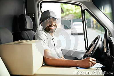 Courier Delivery. Black Man Driver Driving Delivery Car Stock Photo