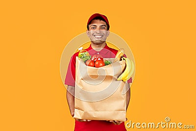 courier guy holds grocery paper bag with products in studio Stock Photo