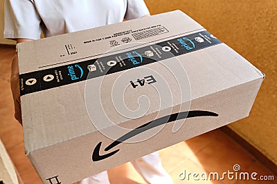 Courier hands holding Amazon premium Prime carton parcel box Editorial Stock Photo