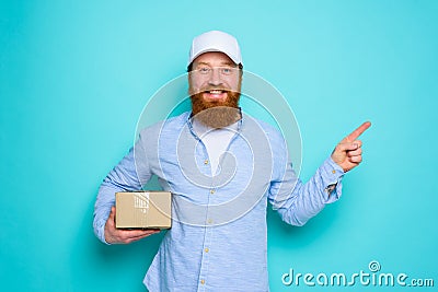 Courier with hat is happy to deliver a carton box and indicates something Stock Photo