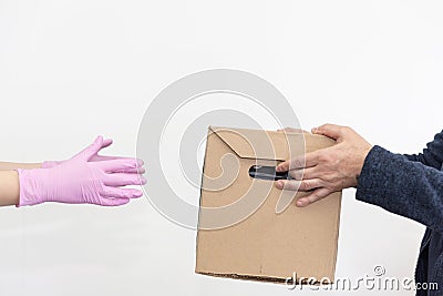 Courier in protective pink gloves hands over a food box to a client. Quarantine. Social distancing. Virus protection Stock Photo