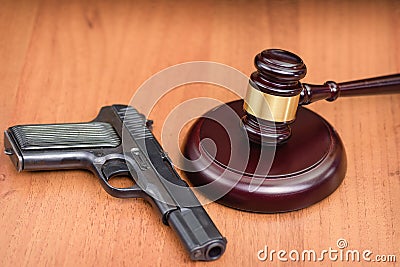 udge`s gavel on wooden table. Judge, hammer, pistol on wooden background Stock Photo