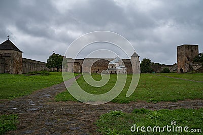 Courtyard of Ivangorod Fortress. View to churches of Saint Nicholas and Dormition of the Mother of God, walls and towers. Editorial Stock Photo