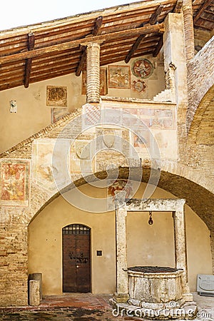 Courtyard with a well and fresco paintings in Italy Editorial Stock Photo