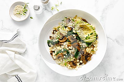 Couscous with avocado, spinach and sauteed champignon mushrooms with onion, top down view Stock Photo