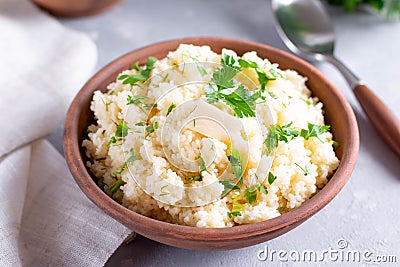 Couscous in a bowl with butter on a light table Stock Photo